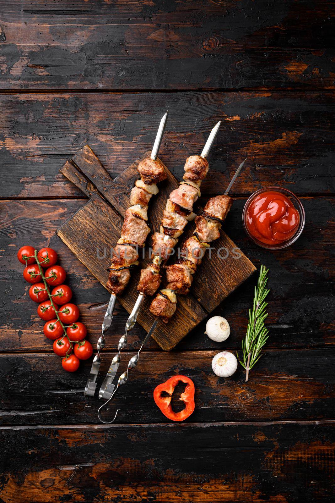 Grilled meat skewers, shish kebab with onion set, on old dark wooden table background, top view flat lay, with copy space for text