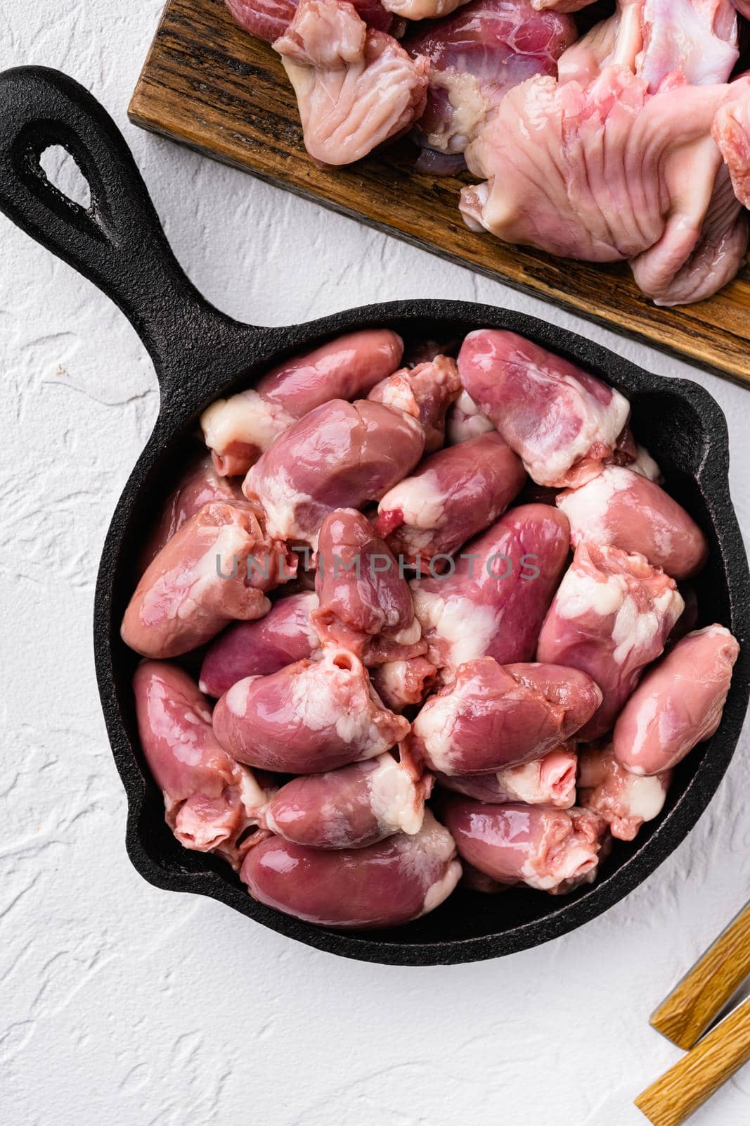 Raw chicken hearts meat set, on white stone table background, top view flat lay