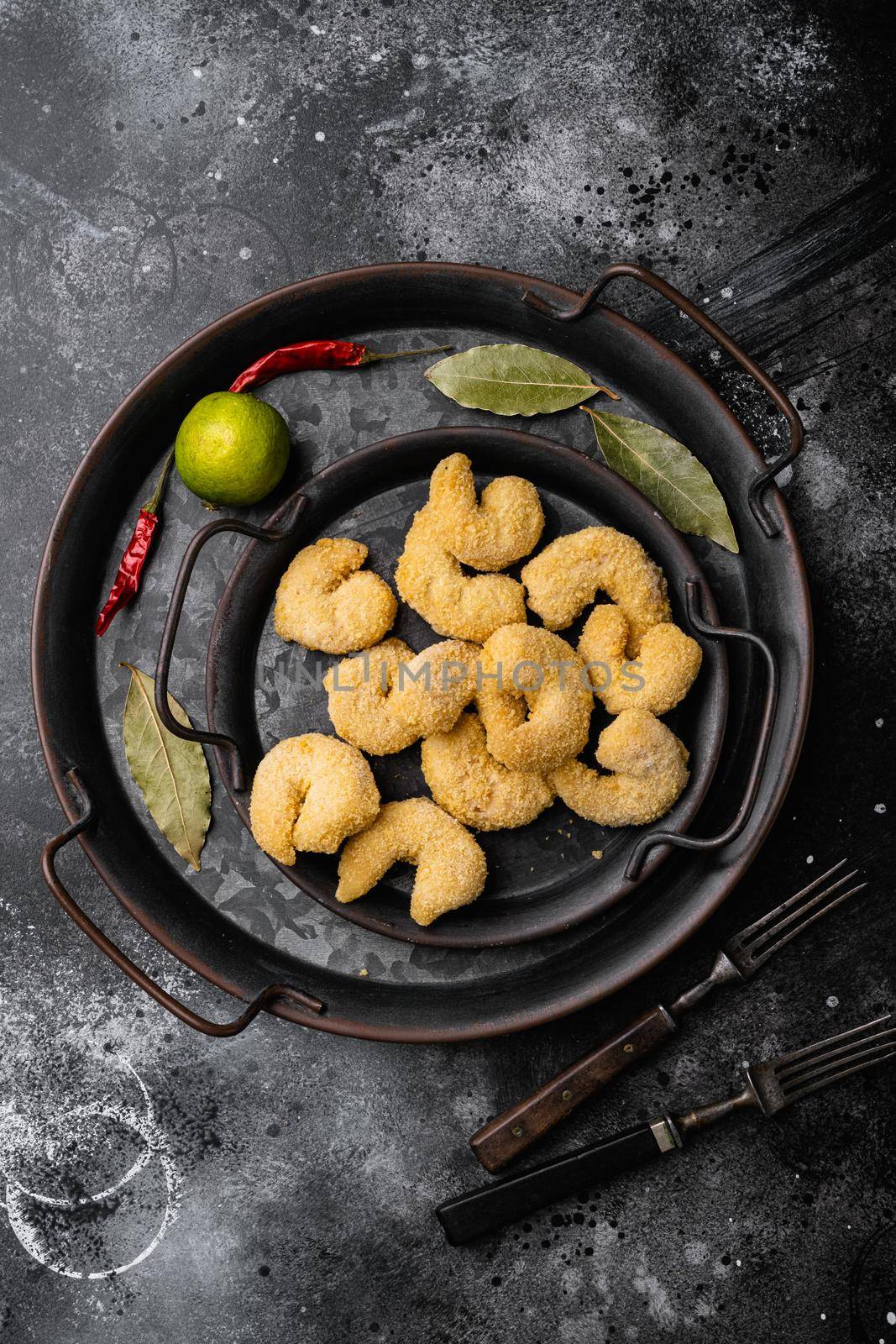 Breaded shrimp ready to cook, on black dark stone table background, top view flat lay, with copy space for text by Ilianesolenyi