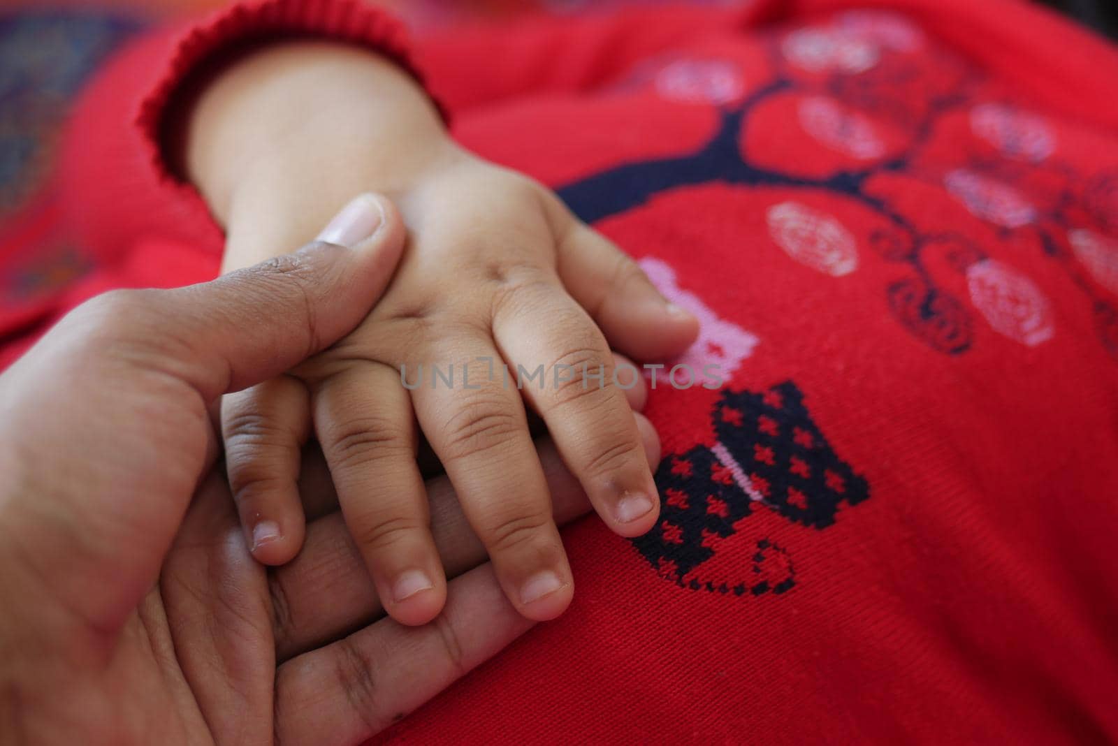 father holding hand of baby child, close up