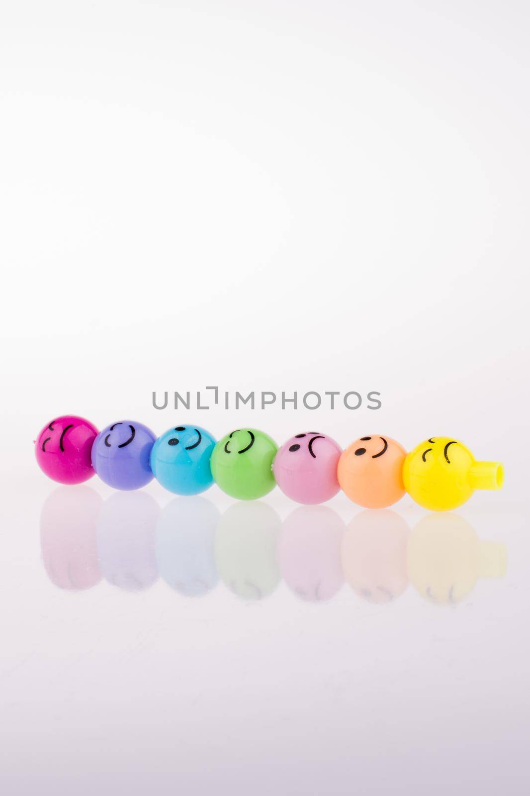 Color beads with facial expression on white background