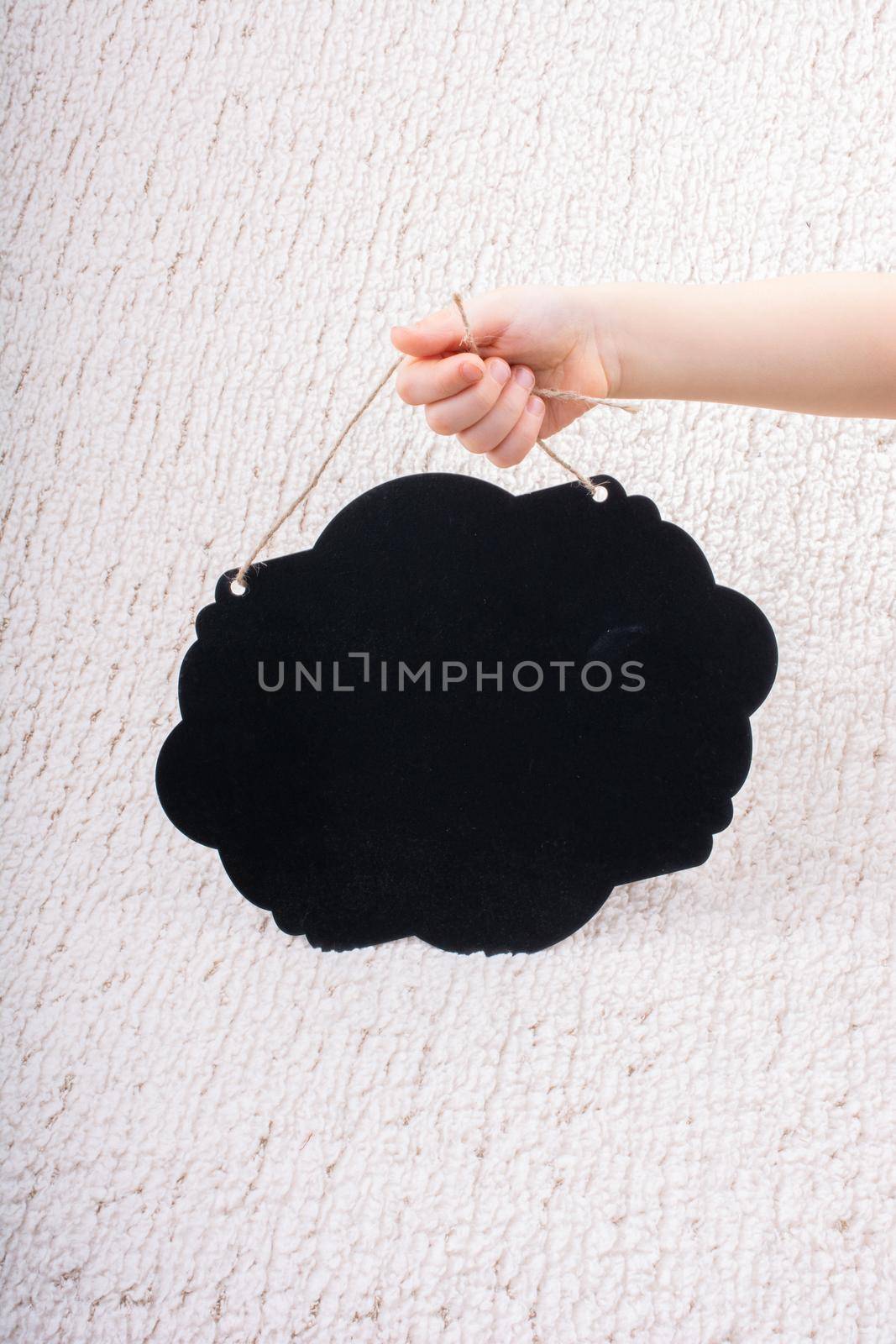 Black speech bubble shaped notice board in hand on white background