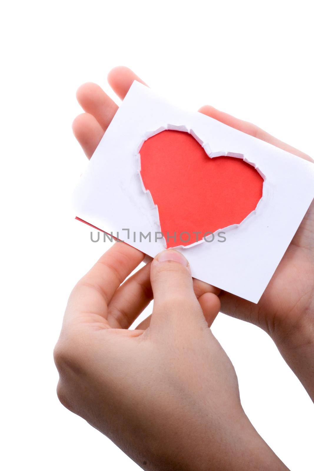 Hand holding a red heart shape paper cut out of paper on a white background