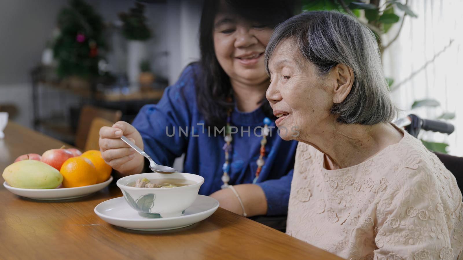 Daughter feeding elderly mother with soup. by toa55