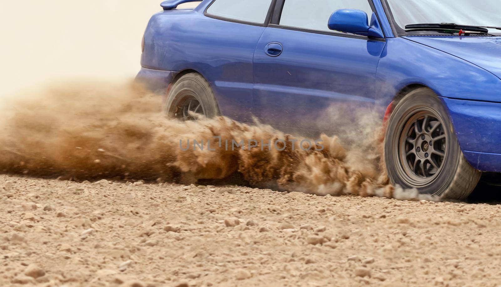 Rally race car drifting on dirt track.