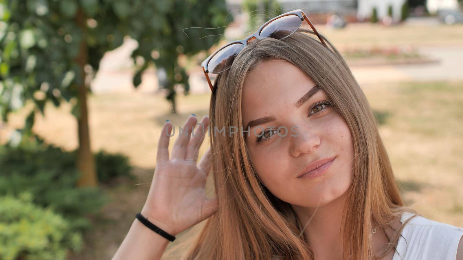 Portrait of a young smiling girl in the park on a summer day. by DovidPro