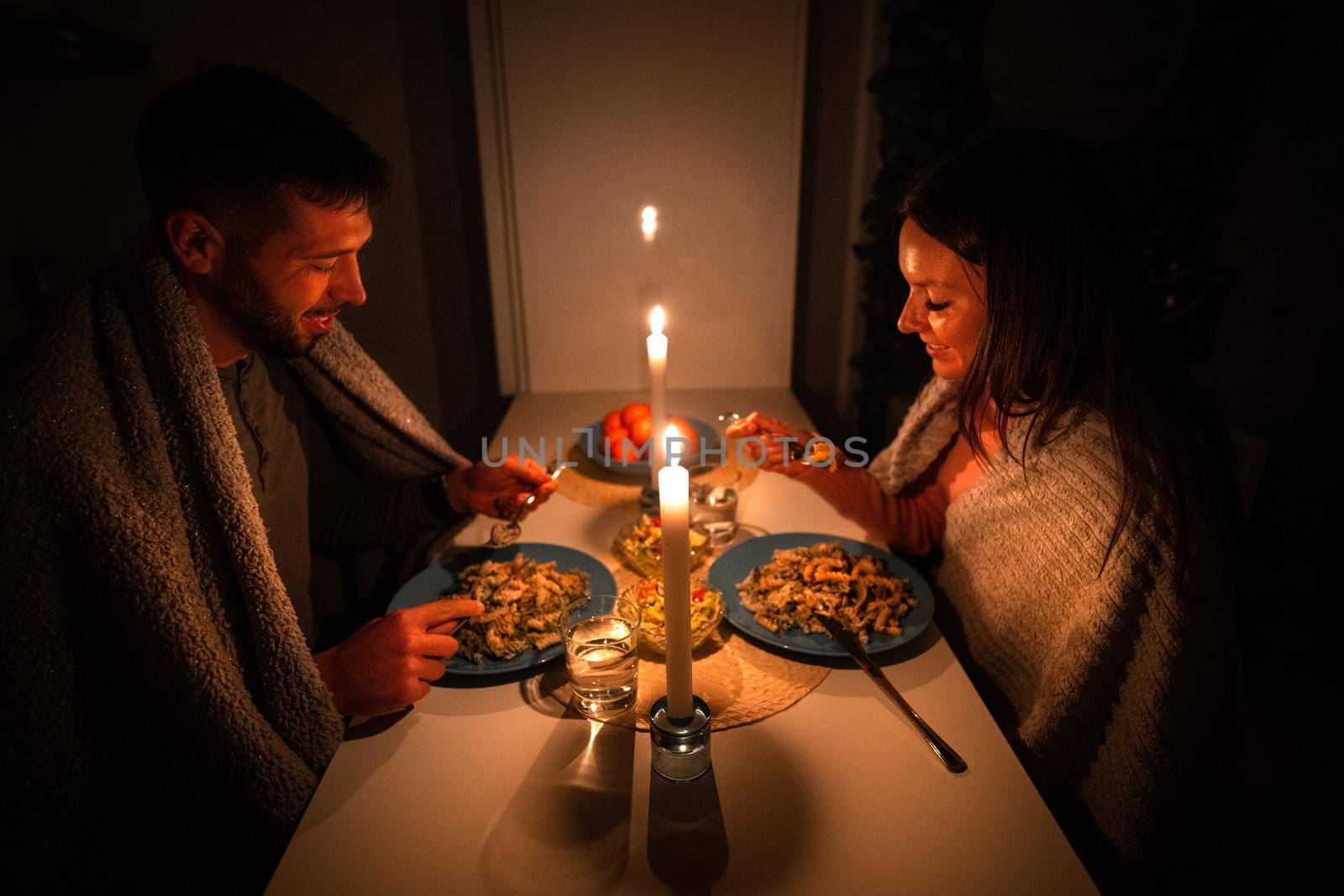 Couple having dinner at home during power outage. Blackout, no electricity. High quality photo