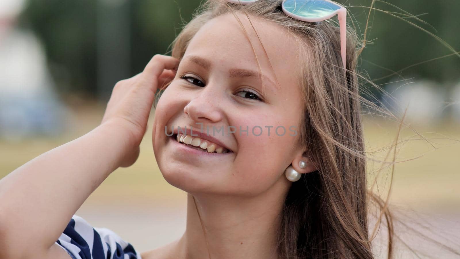 Portrait of a young smiling girl in the park on a summer day. by DovidPro