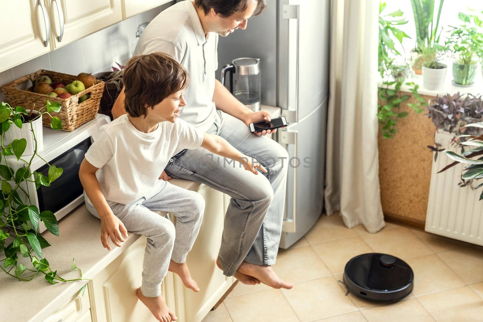 Father and Son Using Robotic Vacuum Cleaner by Syvanych