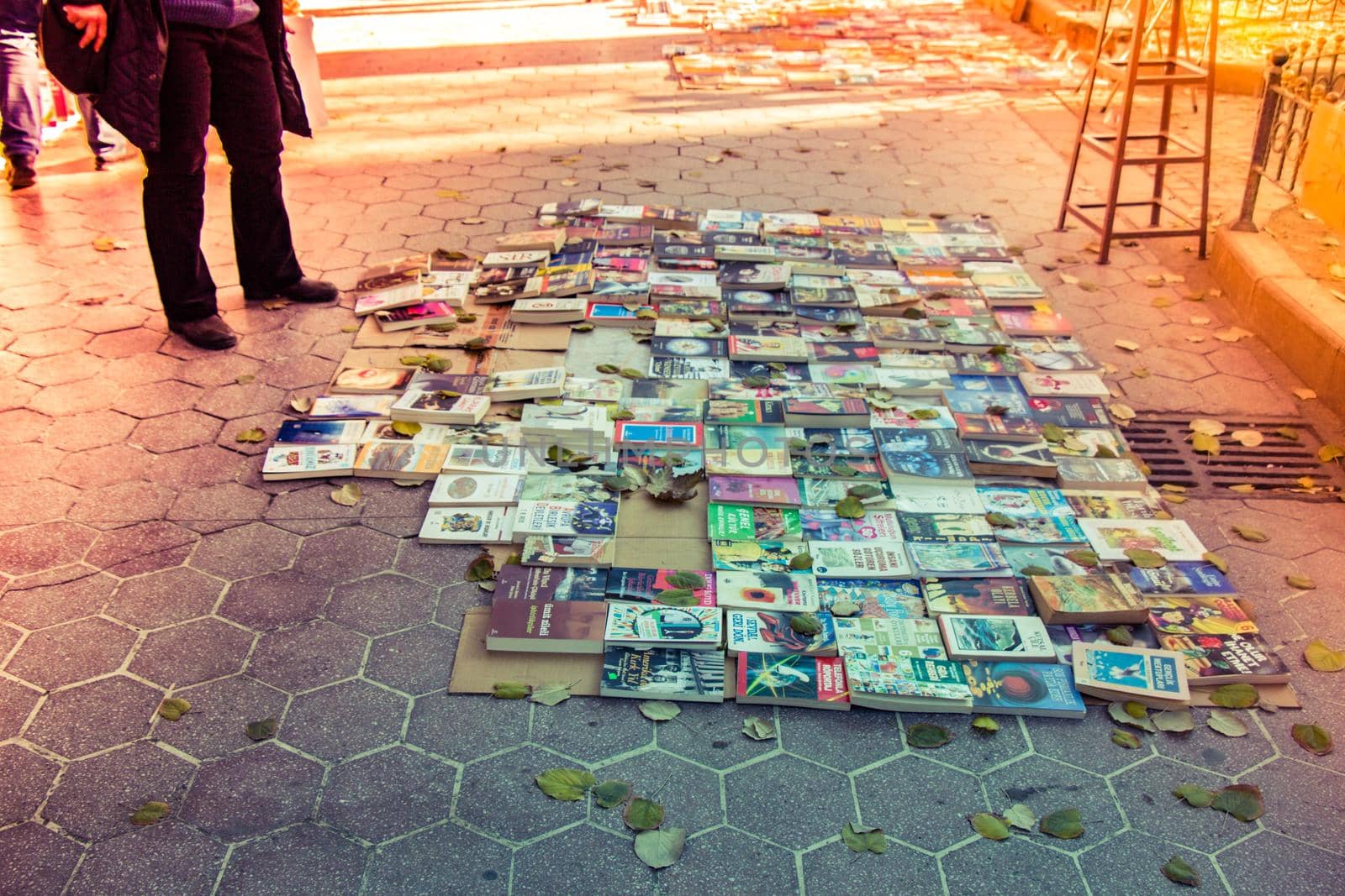 second hand books for sale  laying on the ground in sunlight