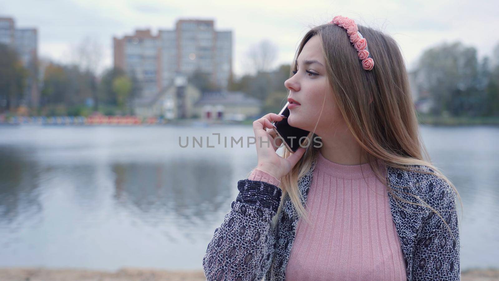 The girl is talking on the phone in the autumn evening. by DovidPro