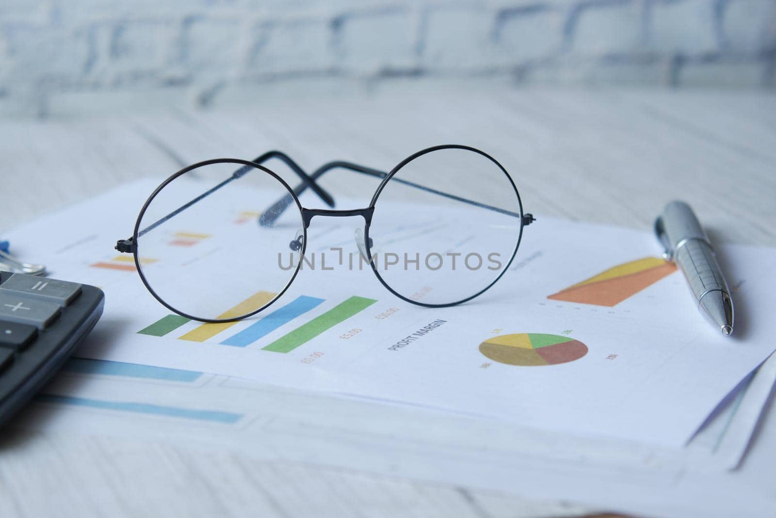 financial graph, calculator and notepad on table.