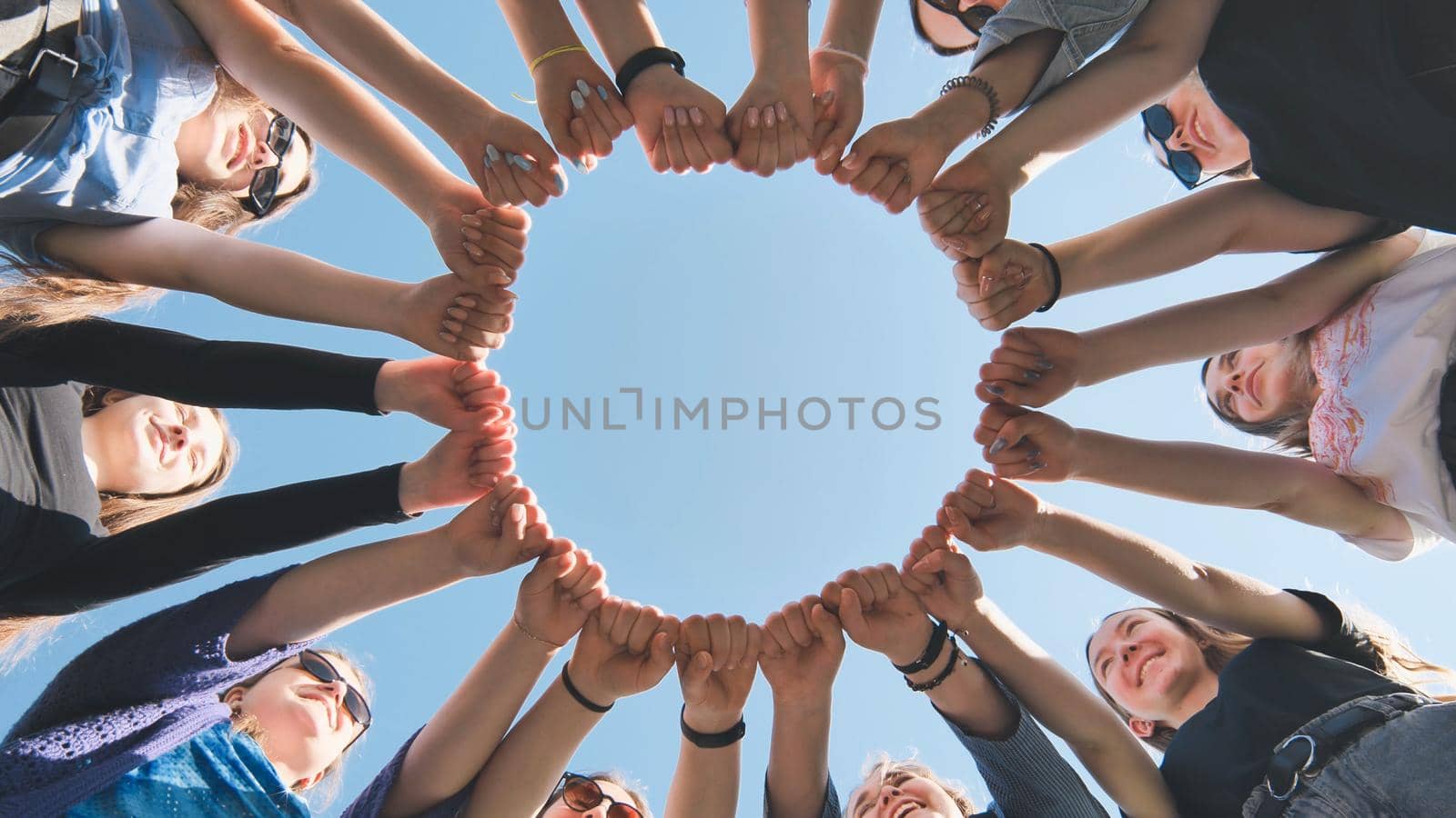 A group of girls makes a circle from their fists of their hands