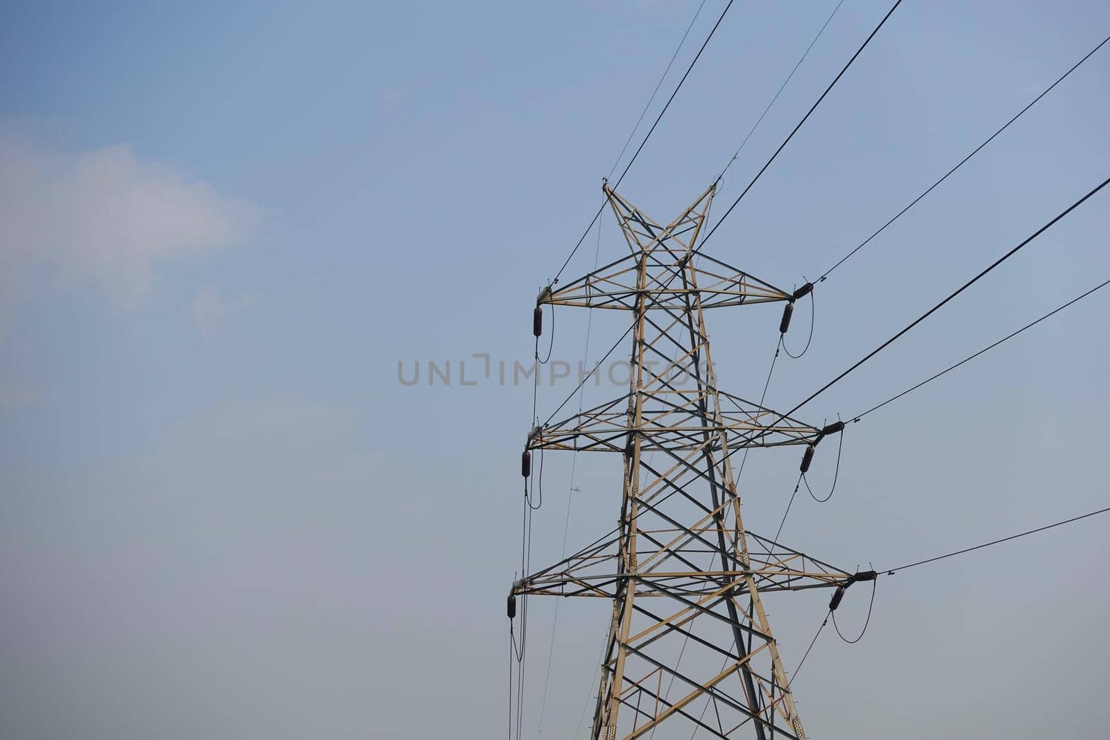 Electric lines against blue sky with copy space .
