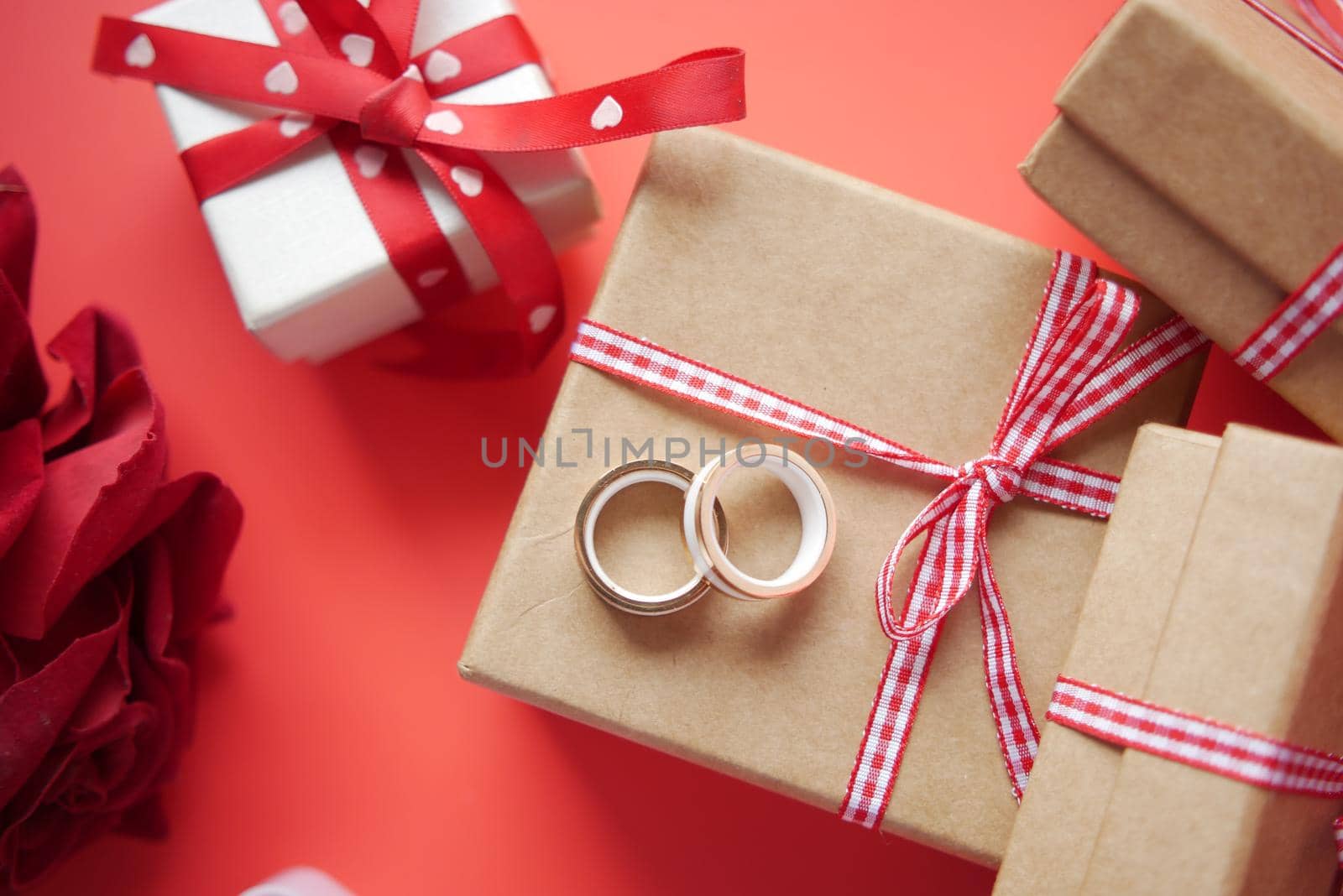 wedding ring and gift box on red background .