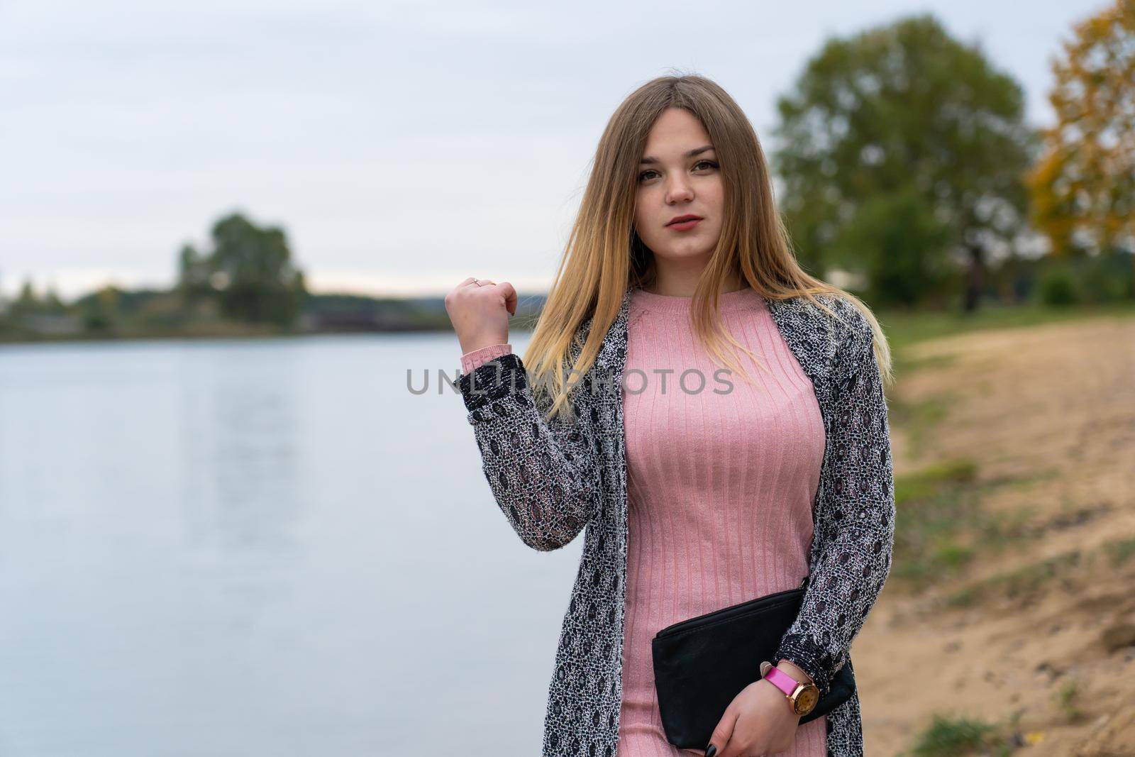 A young girl poses with a handbag posing in a warm autumn evening. by DovidPro