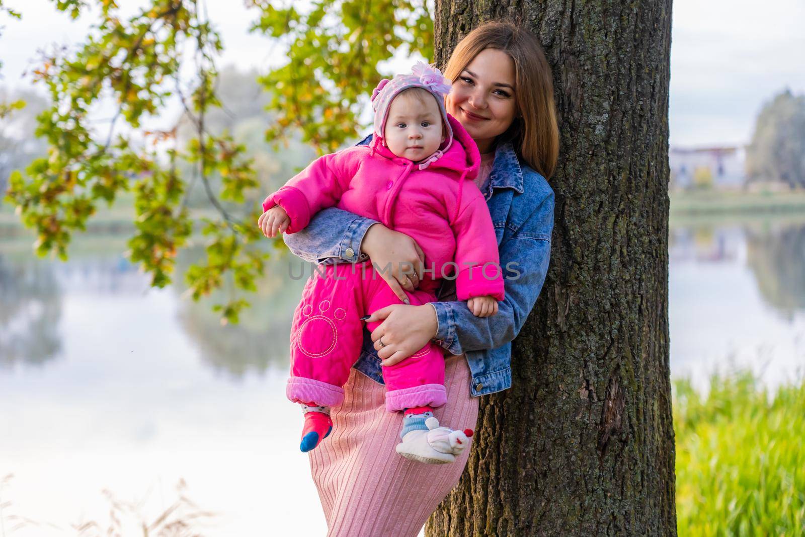 Young mother with her daughter on a warm autumn evening