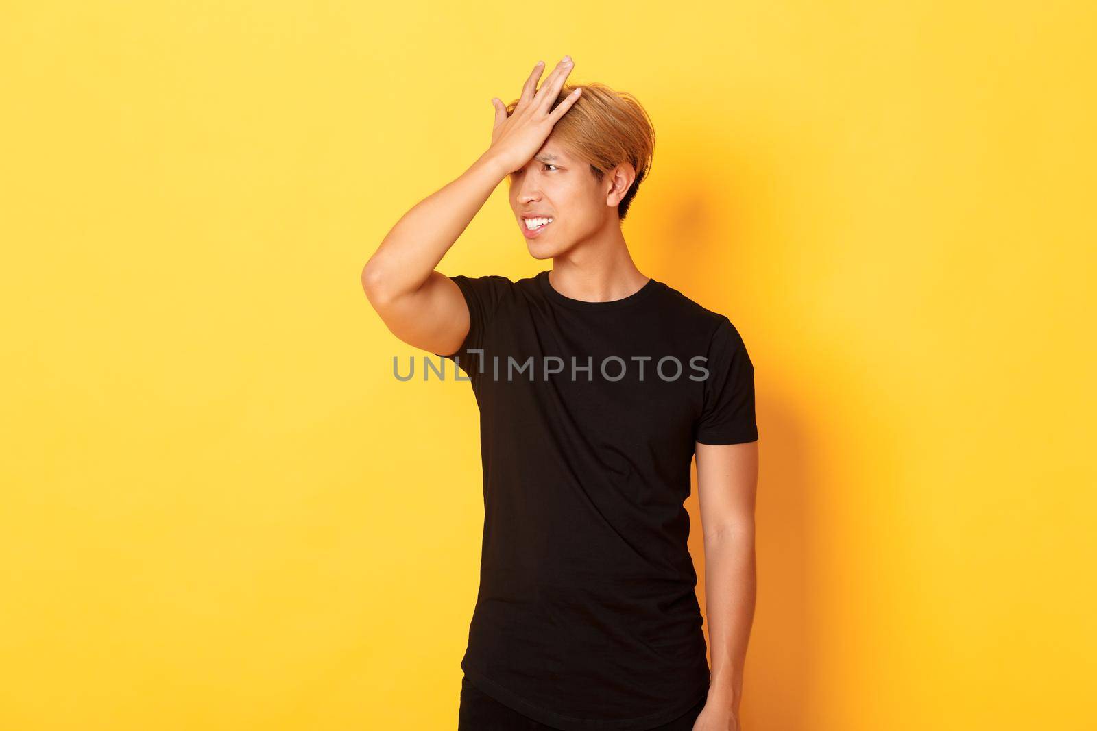 Upset and troubled asian guy snap forehead forgetful, standing over yellow background by Benzoix