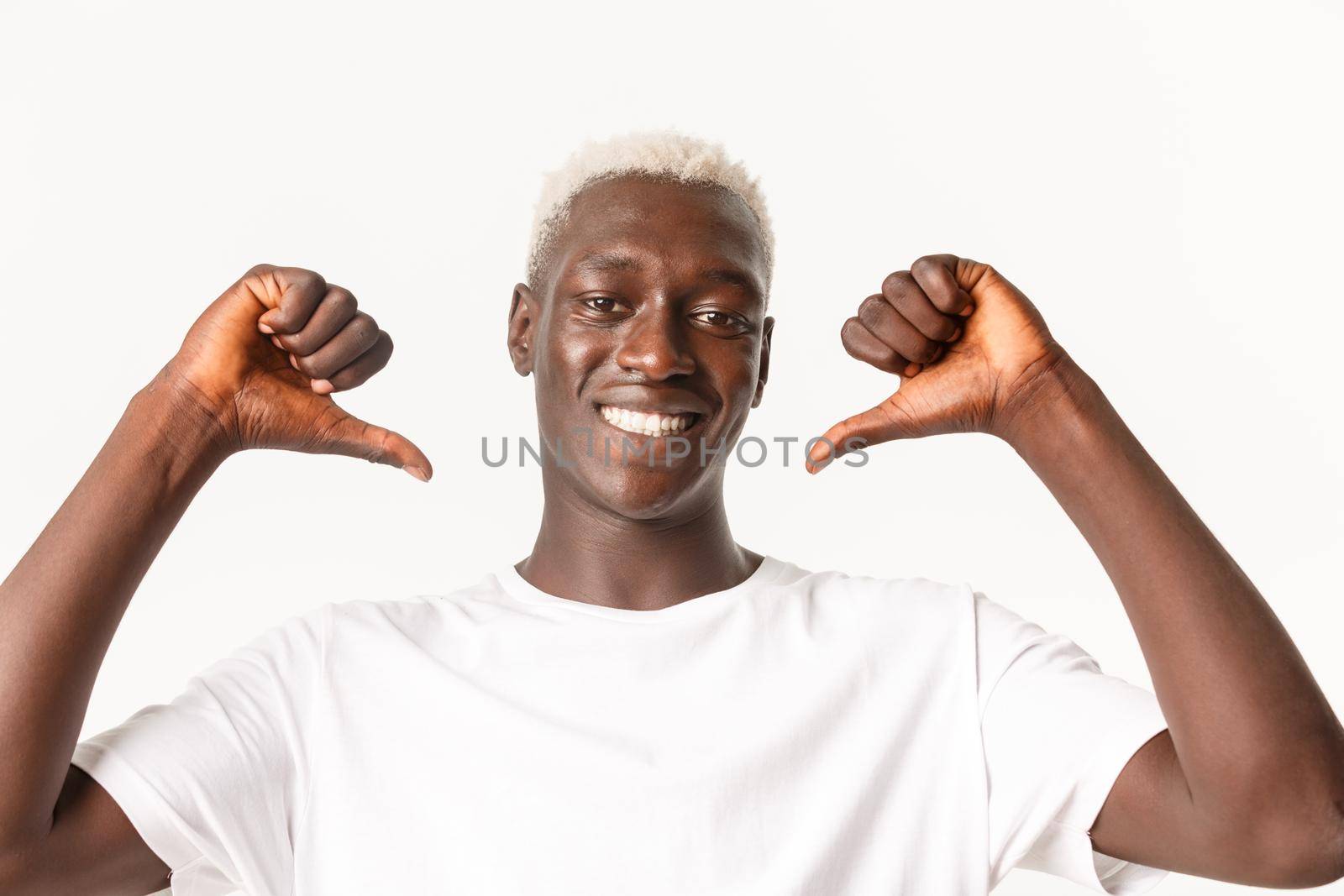 Close-up of confident handsome african-american blond guy pointing at himself proud and assertive, smiling over white background by Benzoix