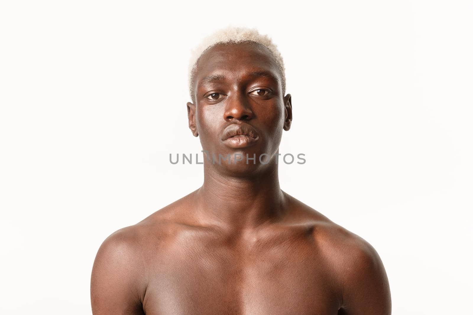Close-up of serious-looking handsome african-american guy with blond hair, standing with bare chest over white background, looking determined by Benzoix