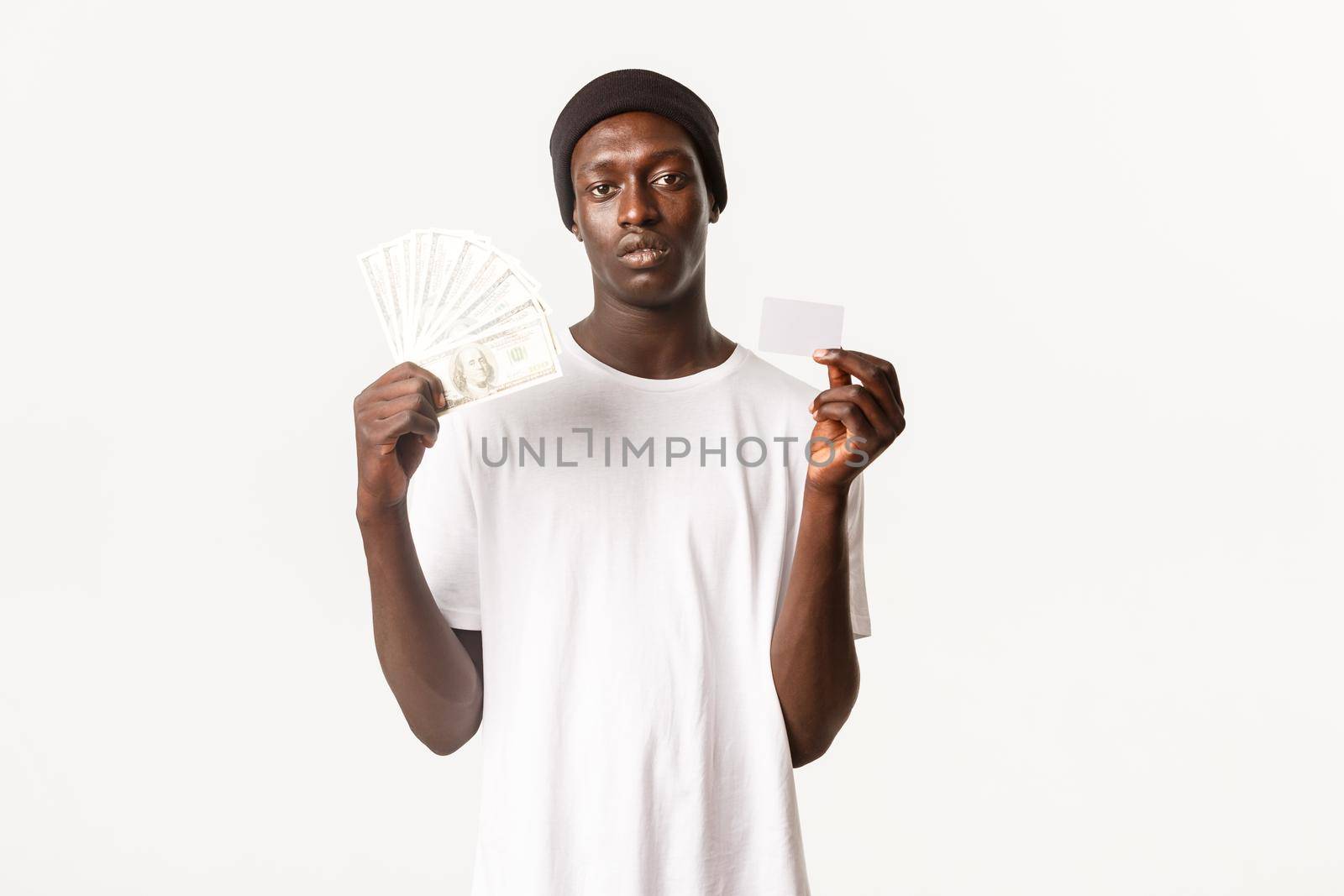 Unbothered cool african-american rich guy showing money and credit card, white background.
