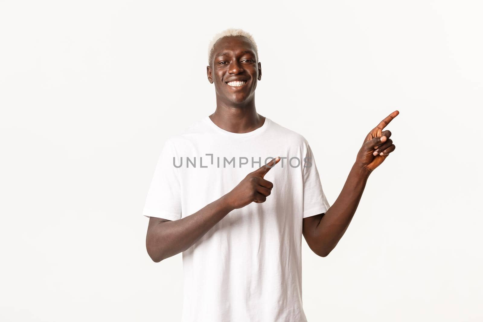 Portrait of satisfied happy african-american blond man, smiling pleased and pointing fingers upper right corner, showing logo, white background.