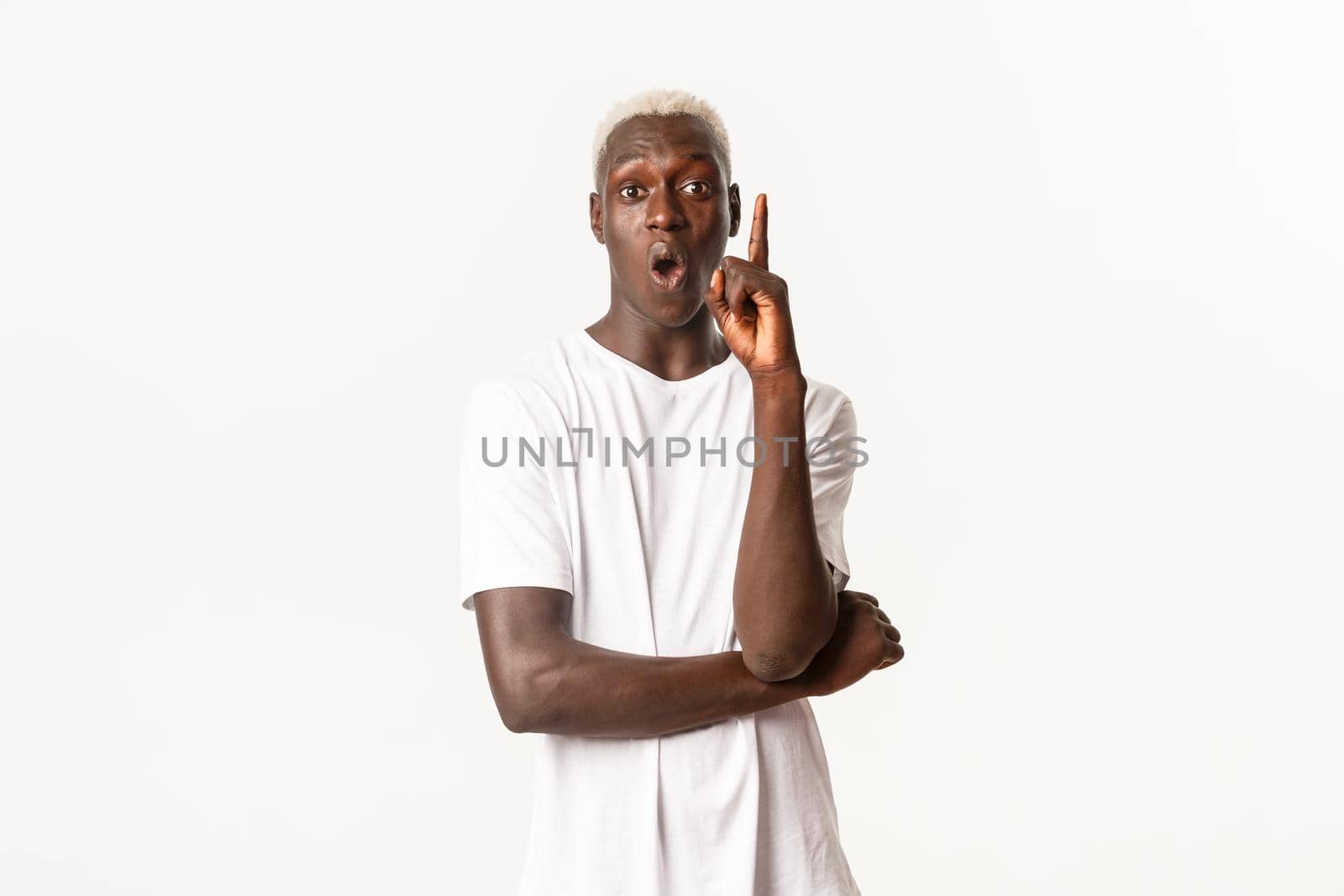 Portrait of thoughtful african-american blond guy, raising finger and saying idea, standing white background.