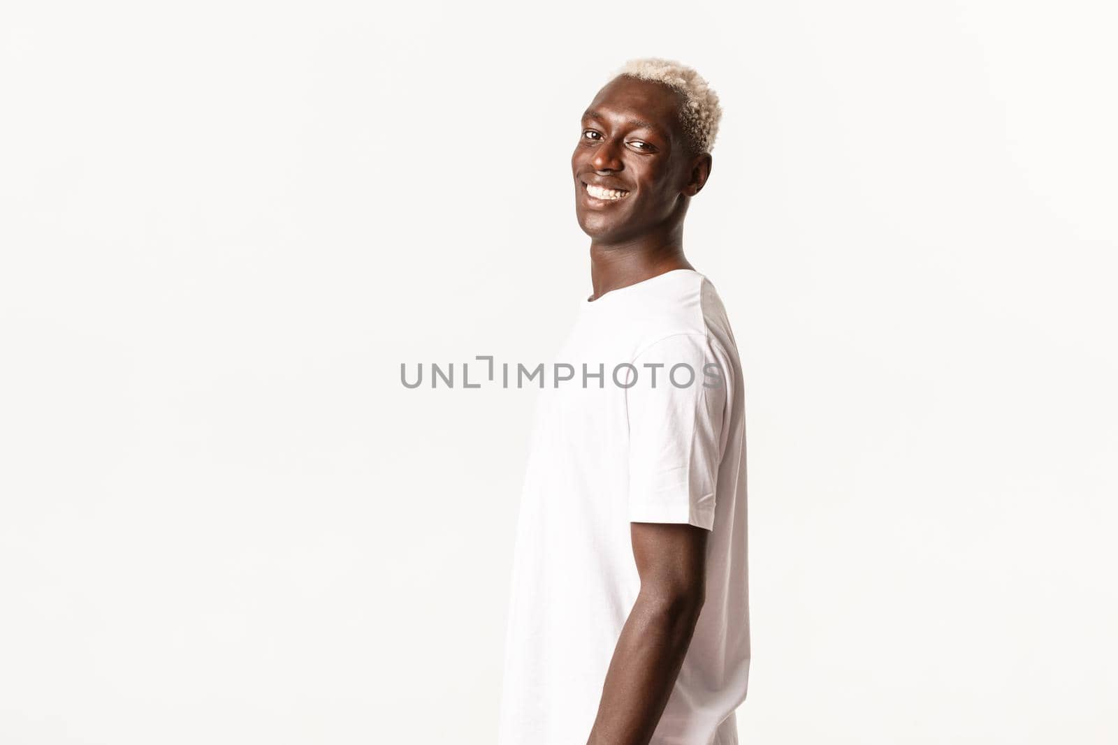 Portrait of happy handsome african-american blond guy turning face at camera, smiling cheerful and standing white background.