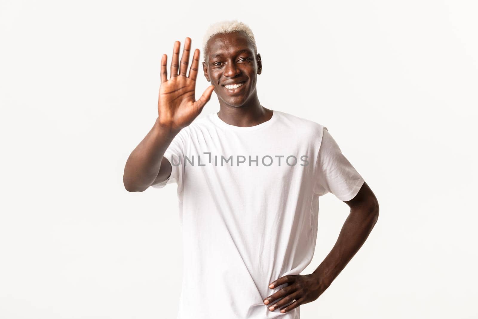 Portrait of cheerful handsome african-american blond guy, smiling satisfied and extending hand for high five, standing white background.