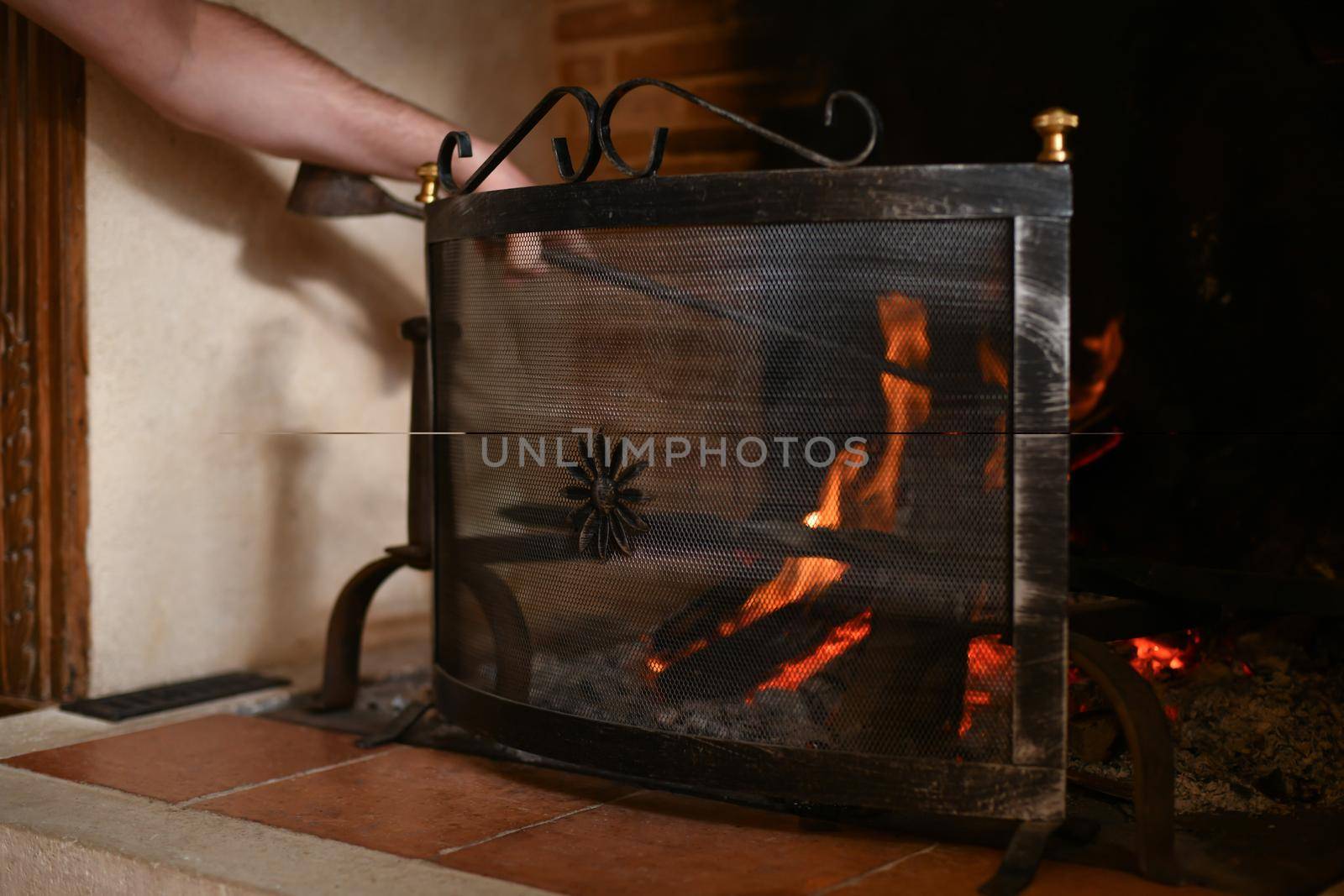 Fire in a french old fireplace with a fire shield