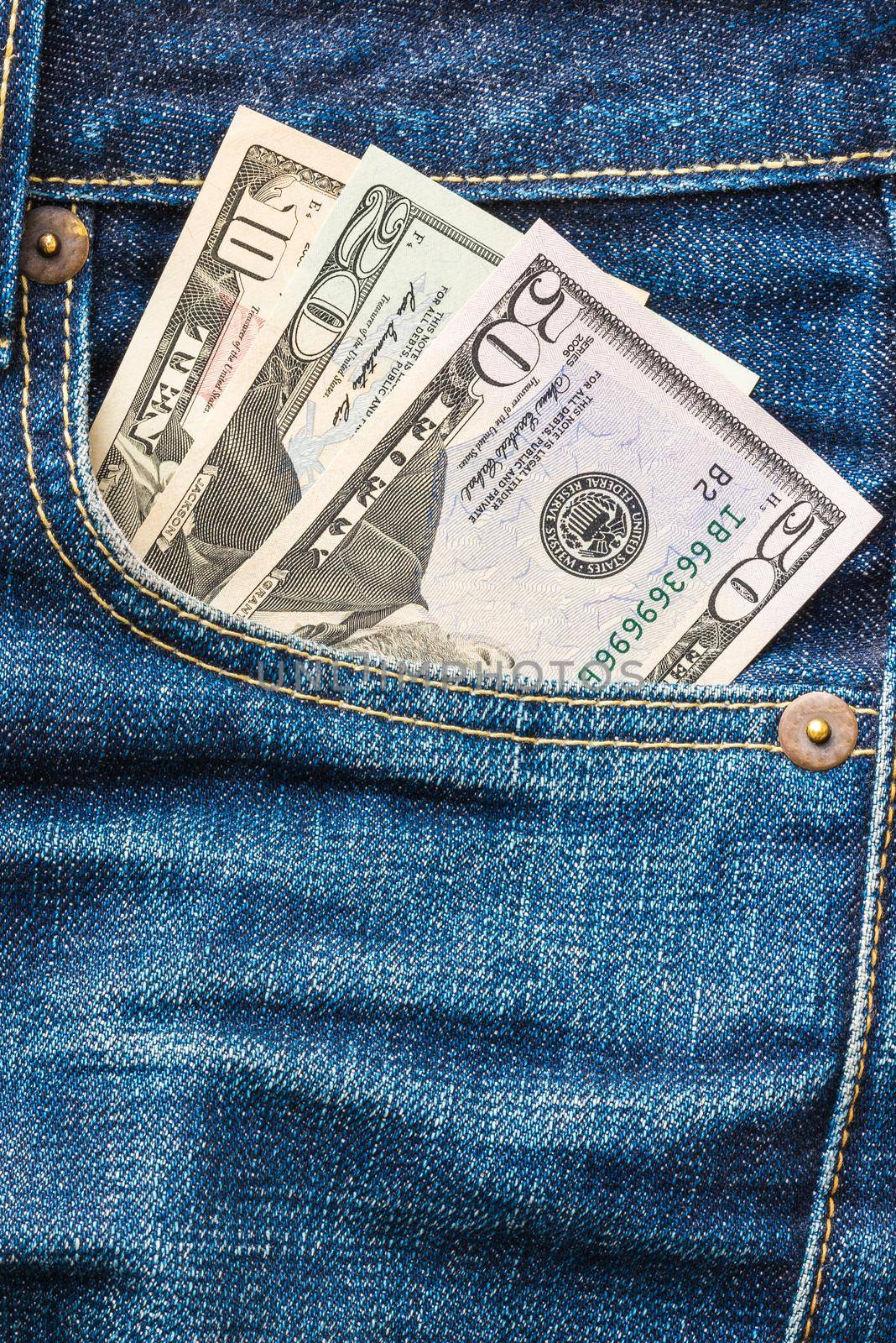 American US Dollar money in the indigo blue jeans pocket. by Nuamfolio