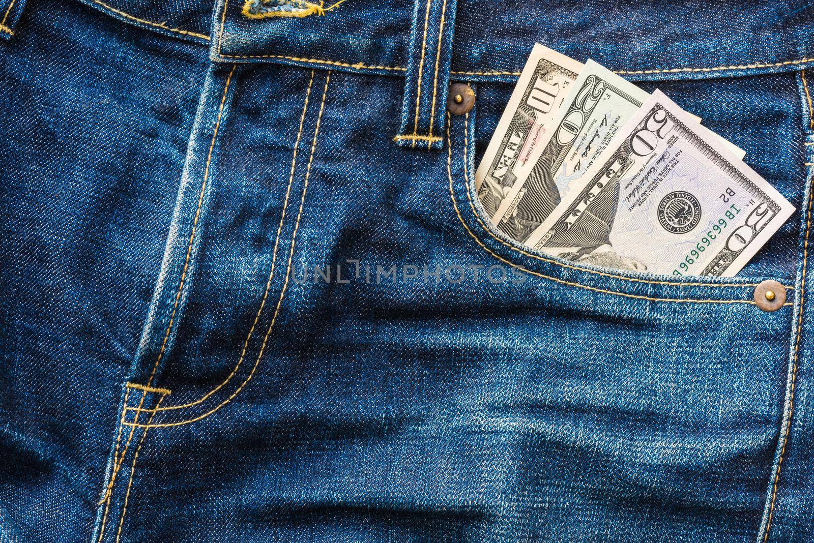 American US Dollar money in the indigo blue jeans pocket by Nuamfolio