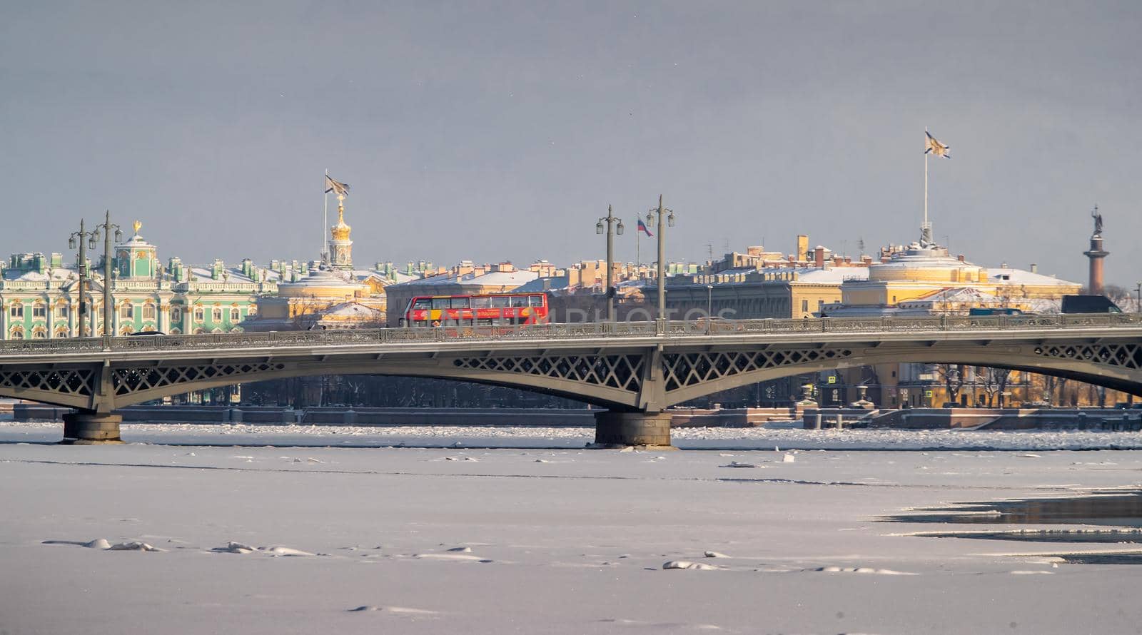 The panoramic view of the winter city Saint-Petersburg, frozen Neva river, the red touristic bus on Blagoveshchensky bridge, Winter Palace, Admiralty building, Alexander column on background. High quality photo