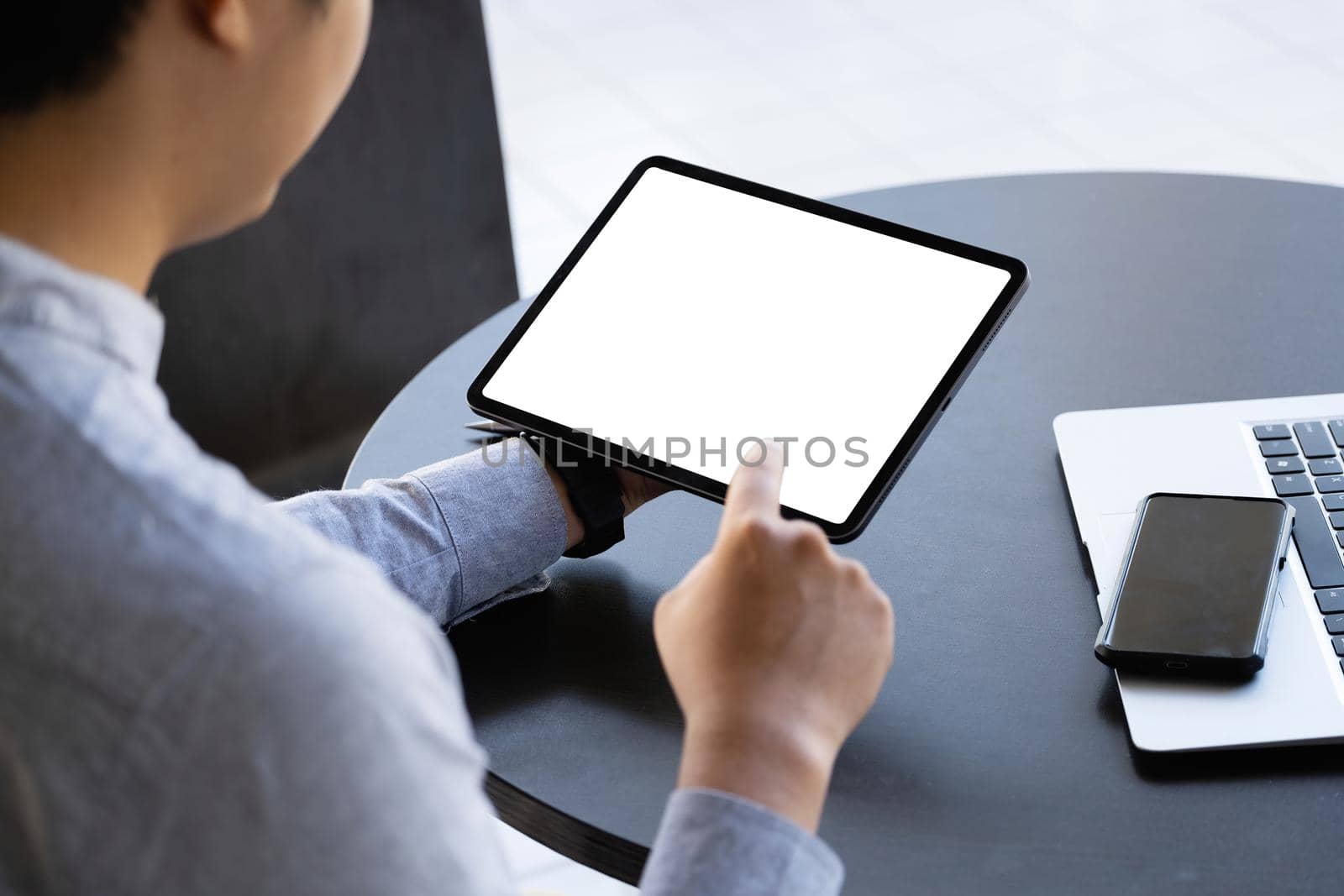 A man holding a tablet with a blank white screen. The blank space on the white screen can be used to write a message or place an image