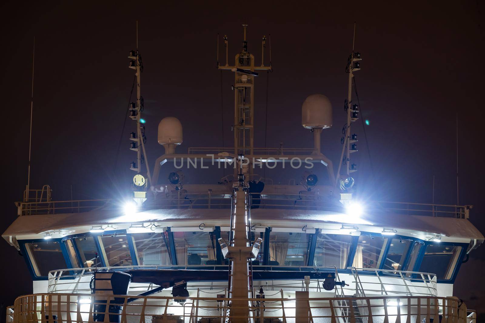 Night close-up of the cockpit of a huge ship with night illumination, fishing trawler, radar equipment at the top. High quality photo