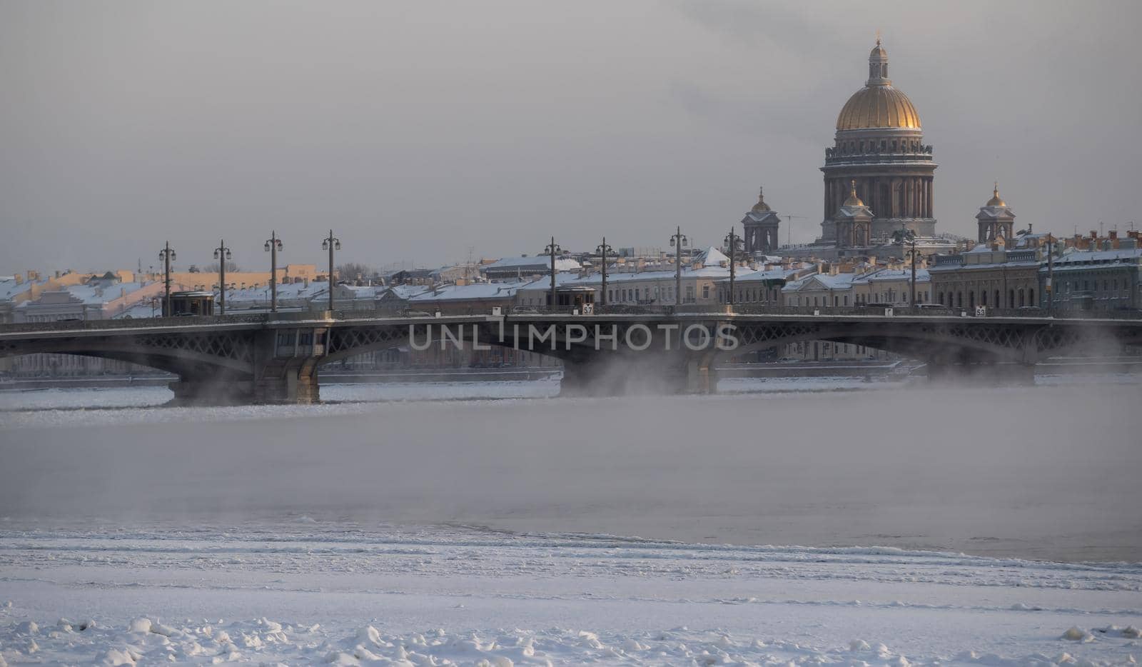 Winter panoramic view of St. Petersburg at frosty day, Isaac cathedral and Blagoveshenskiy bridge on background, steam over frozen Neva river. High quality photo