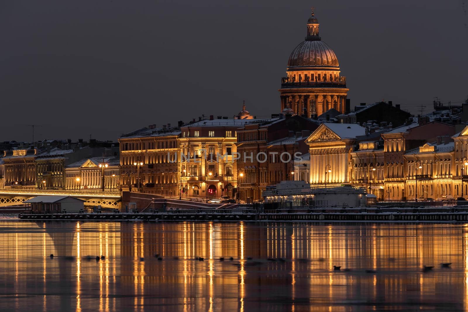 The panoramic footage of the winter night city Saint-Petersburg with picturesque reflection n water, Isaac cathedral on background, Blagoveshchensky bridge, old name is the lieutenant Schmidt. High quality photo