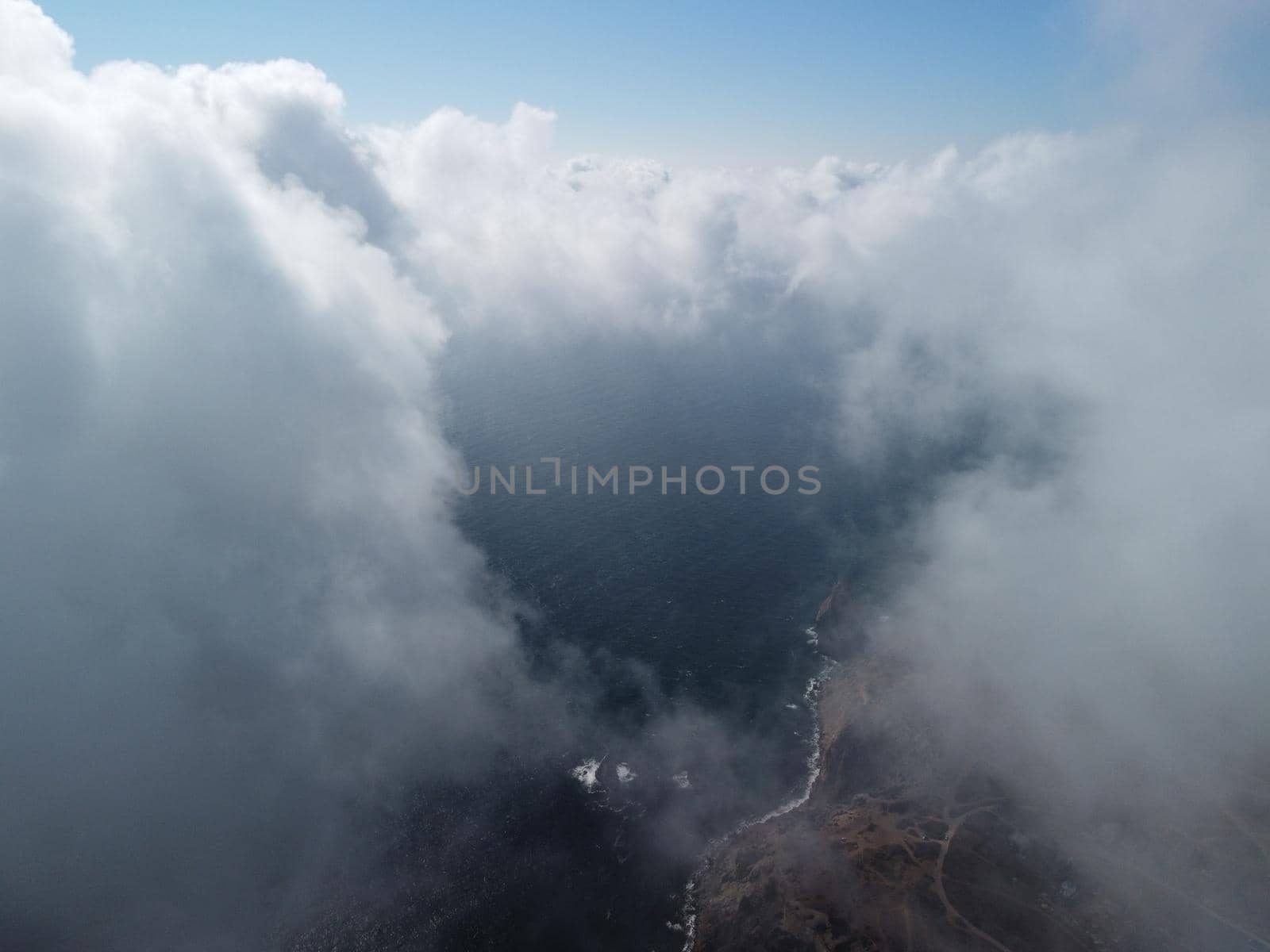 Aerial view. The drone flies over foggy and fluffy clouds. Blue sky sun and sea fog. Abstract aerial nature summer ocean sunset sea and sky background. Vacation, vacation and holiday concept by panophotograph