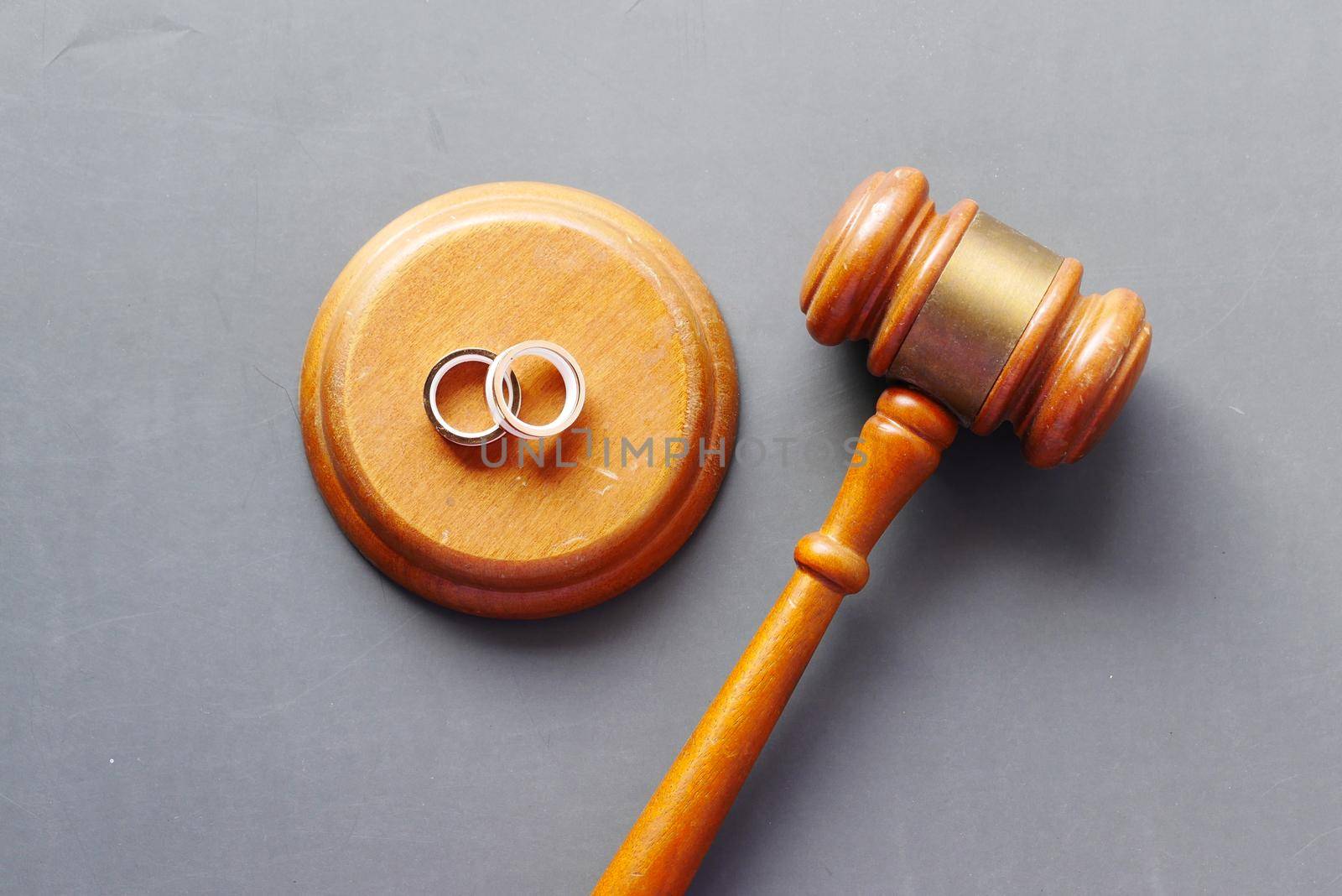 Divorce concept with gavel and wedding rings on table