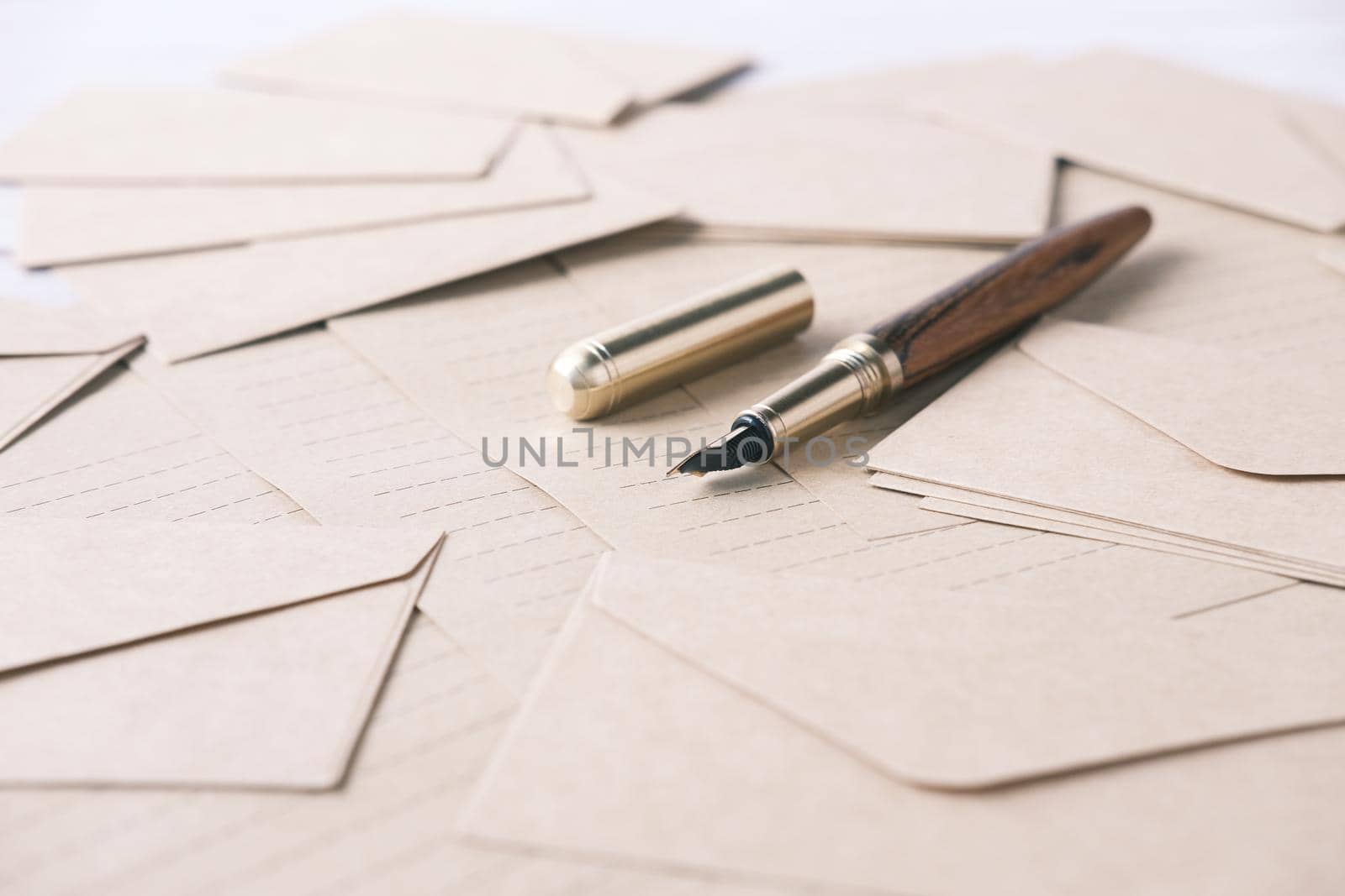 envelope , empty paper and fountain pen on table .