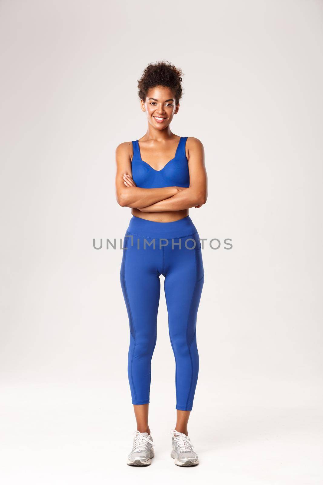 Full length of smiling african-american girl, fitness coach in sportswear, smiling with arms crossed on chest, standing ready for workout over white background.