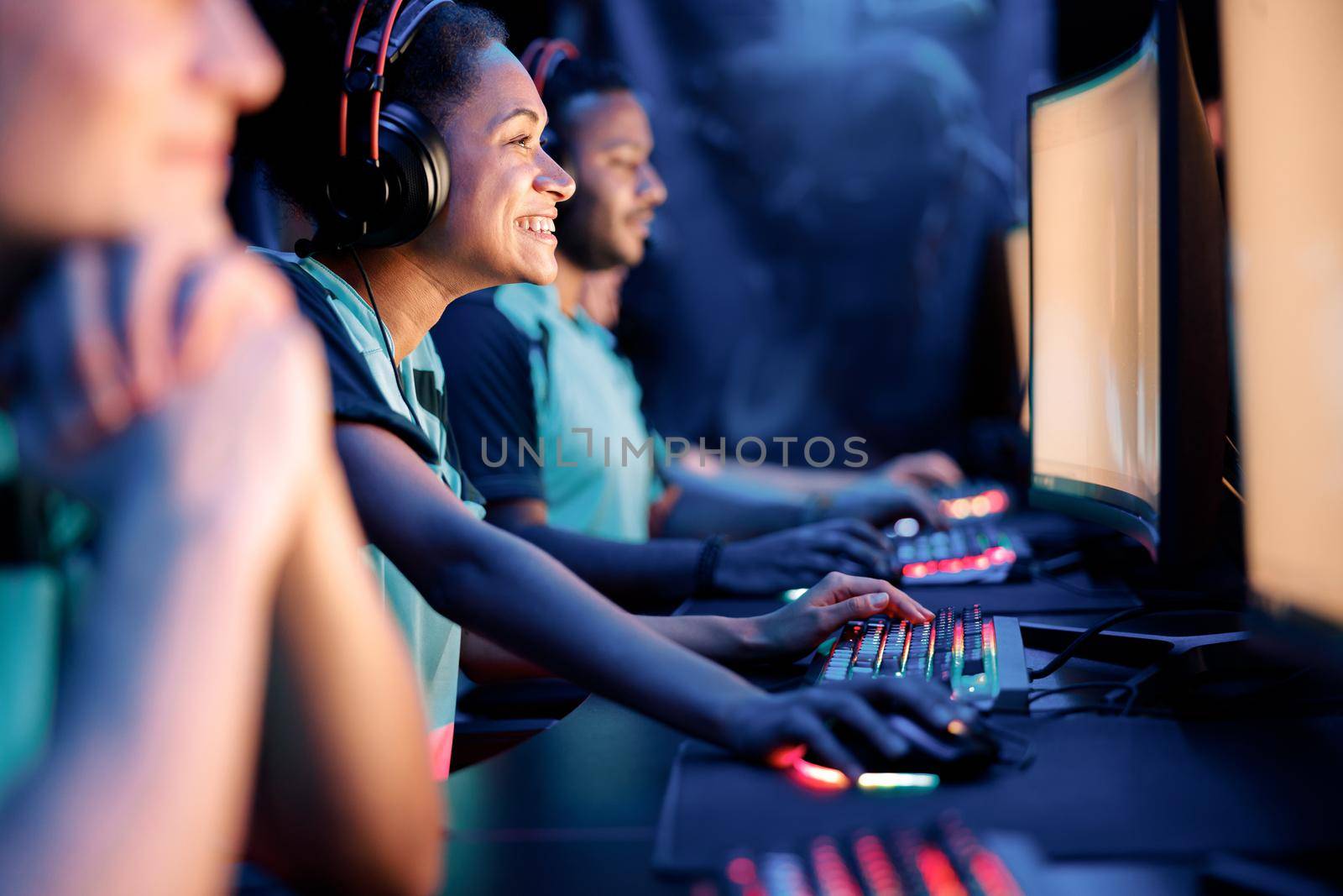 Selective focus on young African woman pro gamer having live stream and playing in online video game at computer club