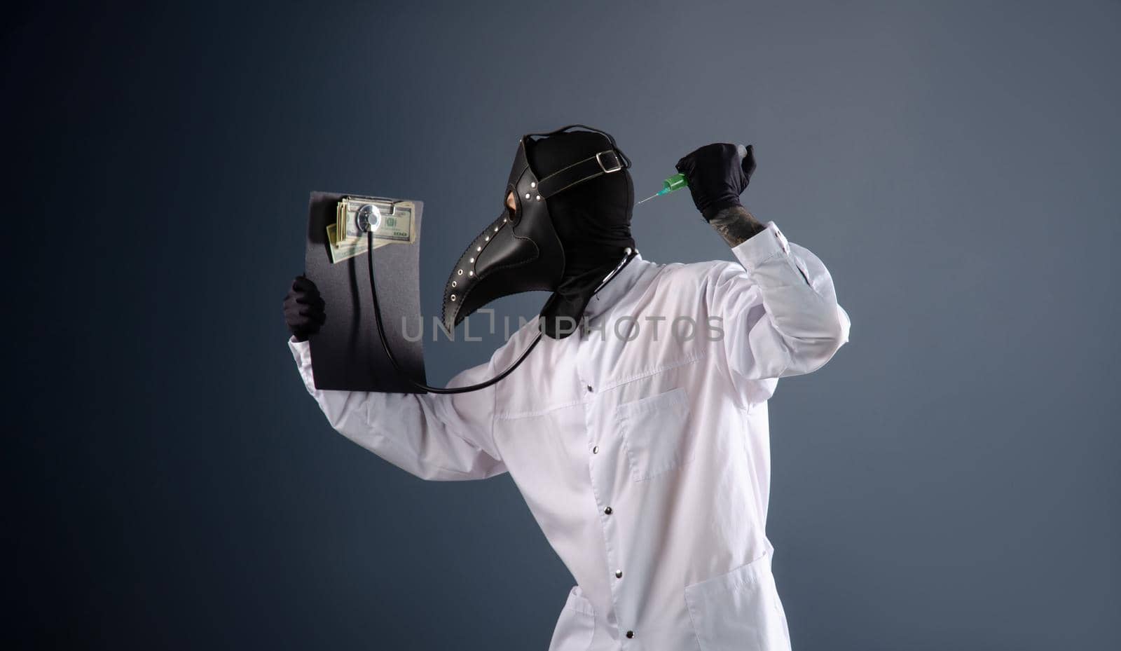 a doctor in a dressing gown, in a plague doctor's mask, is vaccinating