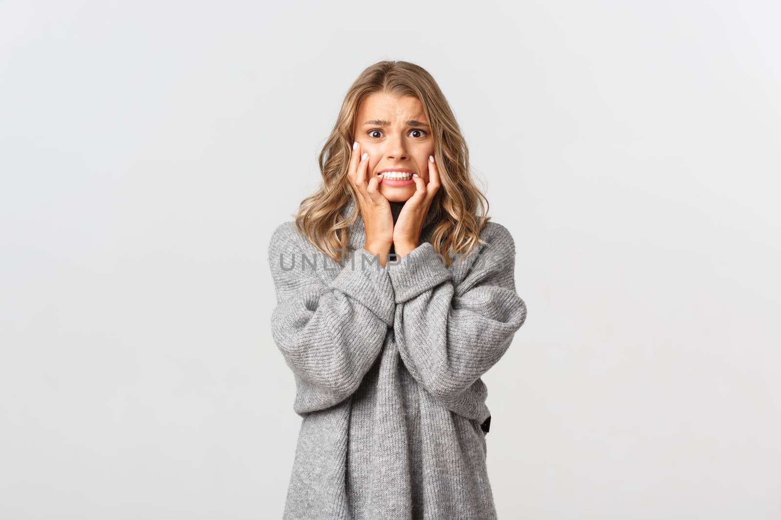 Image of scared blond woman trembling from fear, looking frightened and horrified, standing over white background by Benzoix