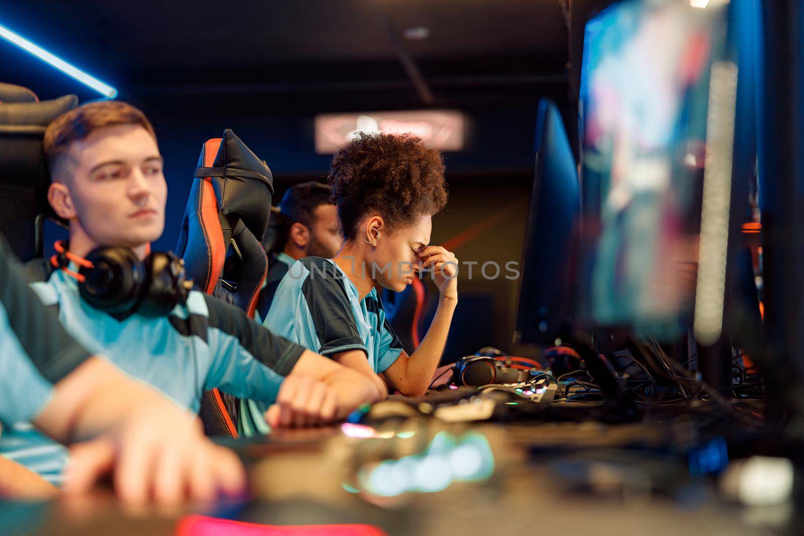 African female cybersport gamer feeling upset about game during participation in multiplayer online esports tournament in gaming club