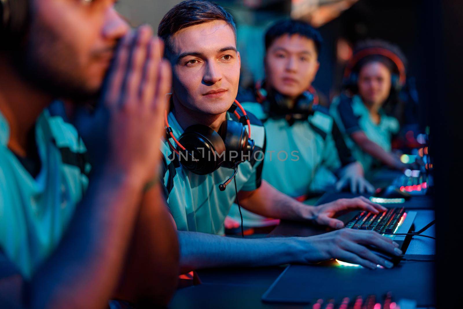 Male concentrated esports player looking at PC monitor in gaming club