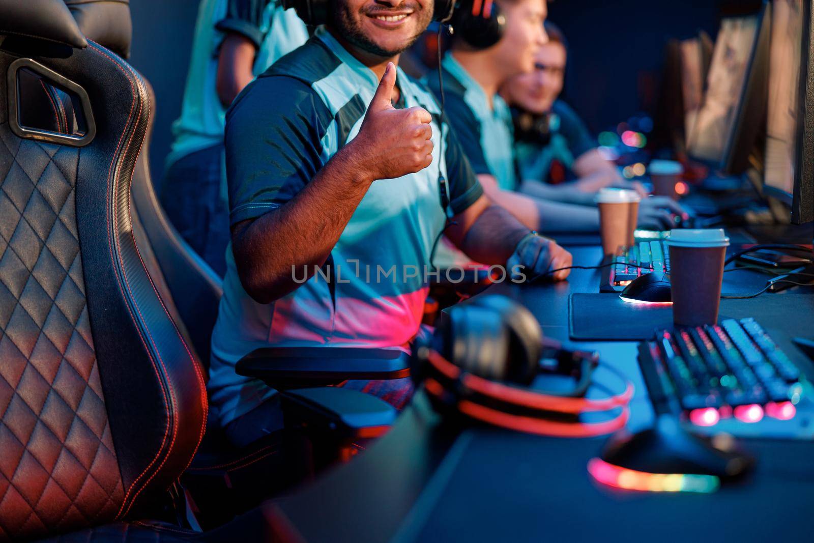 Medium shot of young professional esports player showing approval gesture during participation in international gaming event in computer club
