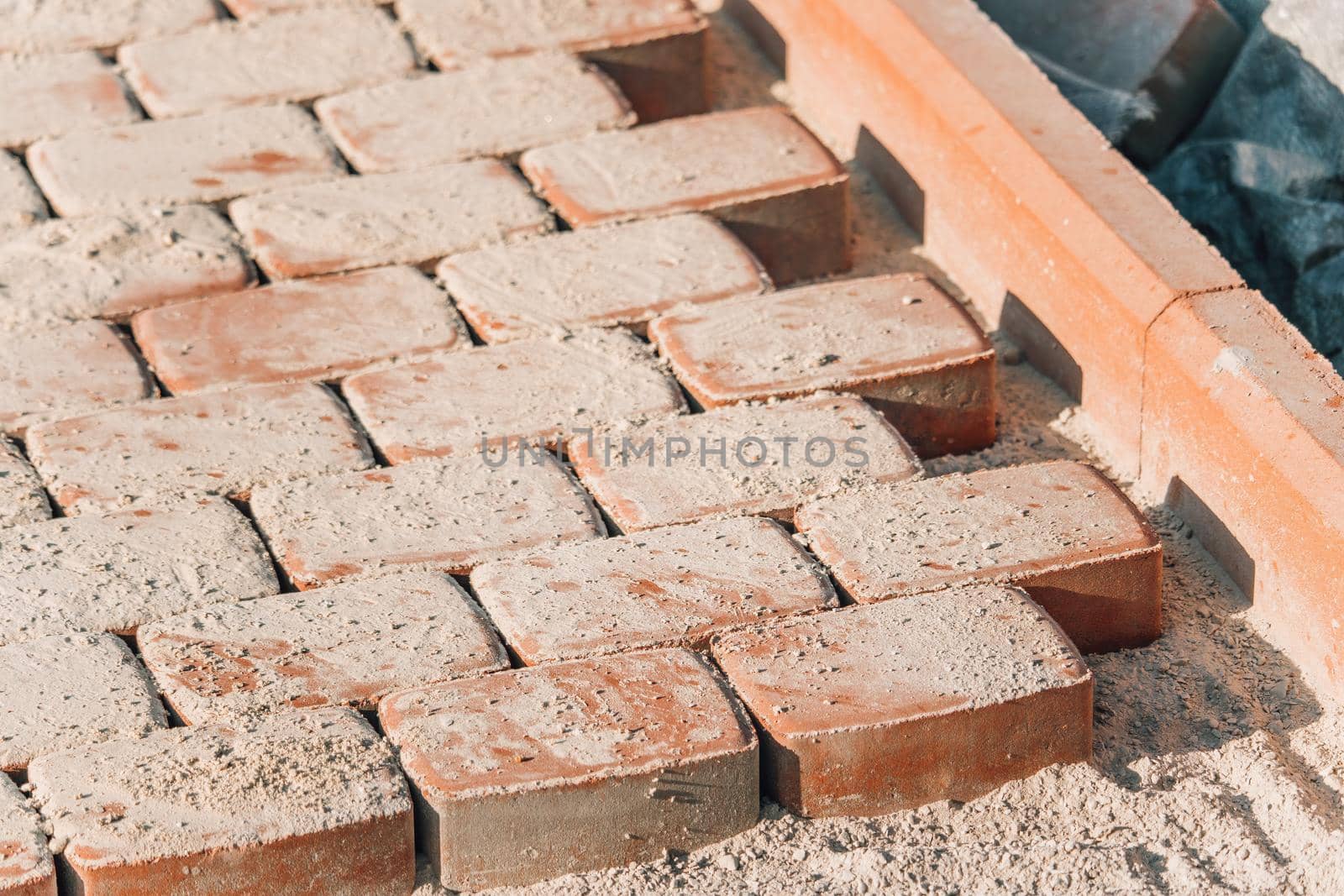 Brown concrete permeable flooring assembled on a substrate of sand. Abstract photo of bricks in the sunlight by panophotograph