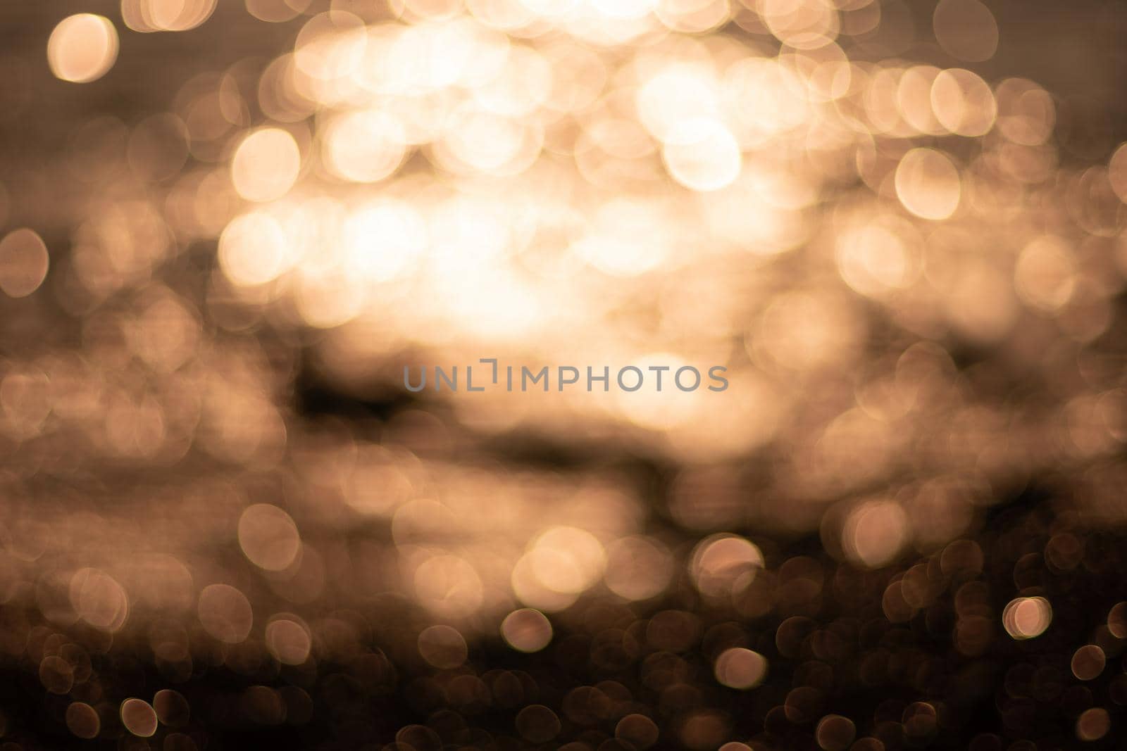 Abstract nature summer or spring ocean sea background. Small waves on water surface in motion blur with bokeh lights from sunrise.