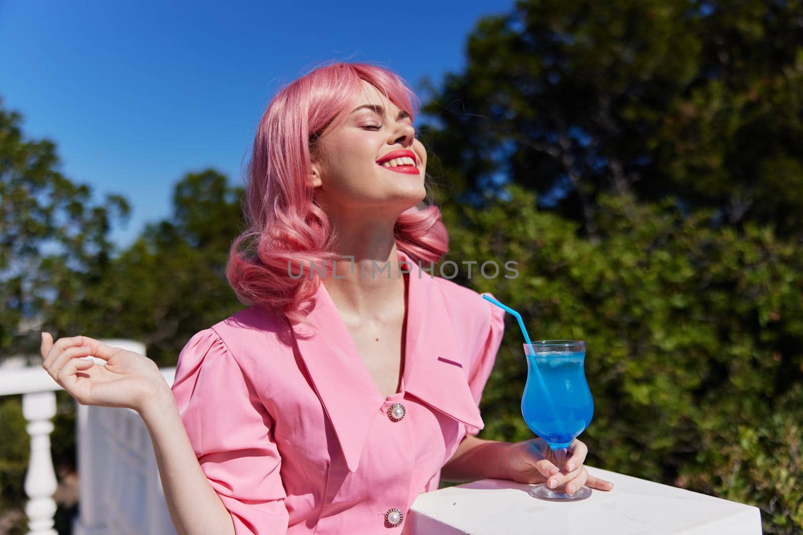 Young female in pink dress outdoors with cocktail Happy female relaxing. High quality photo